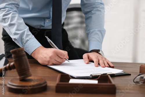Lawyer working at wooden table in office, closeup