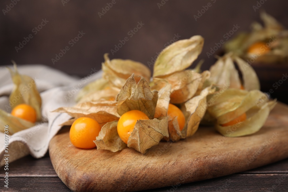 Ripe physalis fruits with calyxes on wooden table, closeup Ripe physalis fruits with calyxes on wooden table, closeup