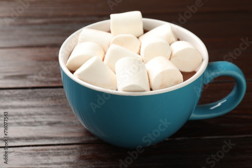 Tasty hot chocolate with marshmallows on wooden table, closeup