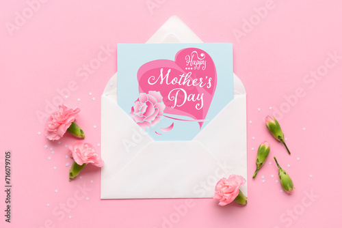 Envelope with greeting card for Mother's Day and flowers on pink background, top view © Pixel-Shot