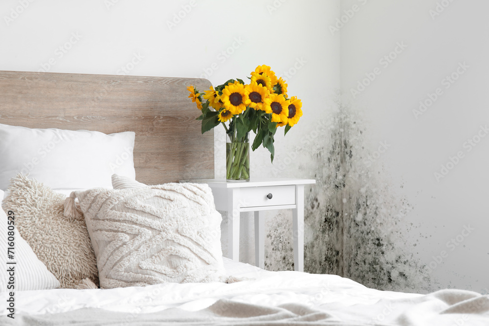 Interior of light bedroom with bouquet of sunflowers on bedside table - obrazy, fototapety, plakaty 