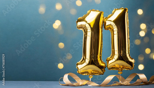 Banner with number 11 golden balloon with copy space. eleven years anniversary celebration concept on a blue background.