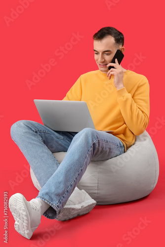 Young man with laptop talki...