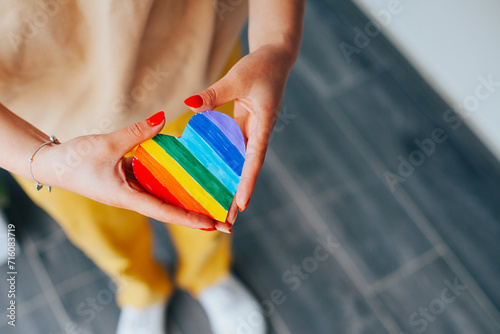 Photograph of woman's hands holding a hand drawn LGBTQ+ heart. Concept of people and lifestyles.