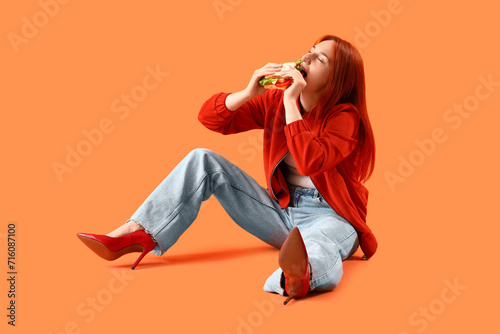Young redhead woman eating ...