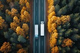 Drone captures autumnal forest road two trucks viewed from above
