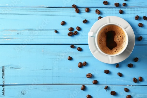 Top view of a blue wooden background with a fresh cup of coffee