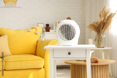 Electric fan heater on table in children's room photo