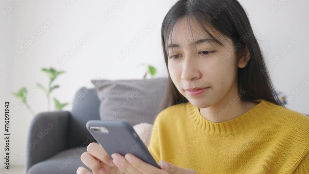 Asian girl happy smile typing using smartphone at home Asian girl happy smile typing using smartphone at home
