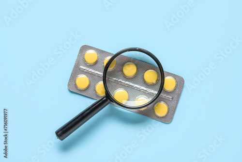 Magnifier with pills on blu...