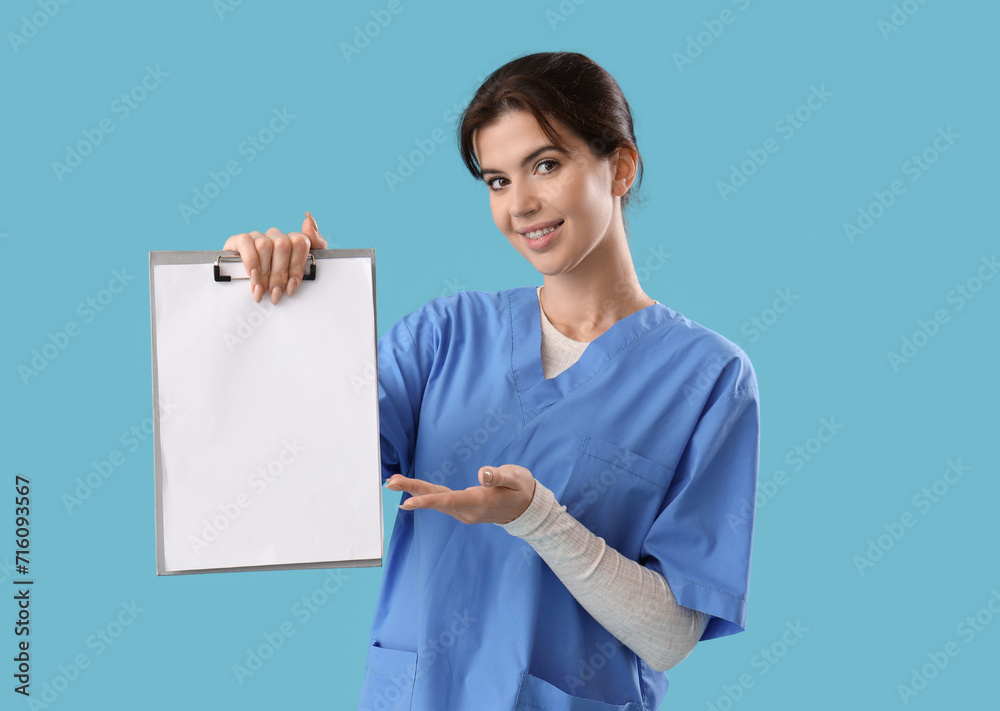 Female medical intern with clipboard on blue background Female medical intern with clipboard on blue background