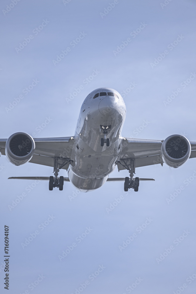 Naklejka premium View of the underside of the fuselage of a passenger plane at low altitude near the runway