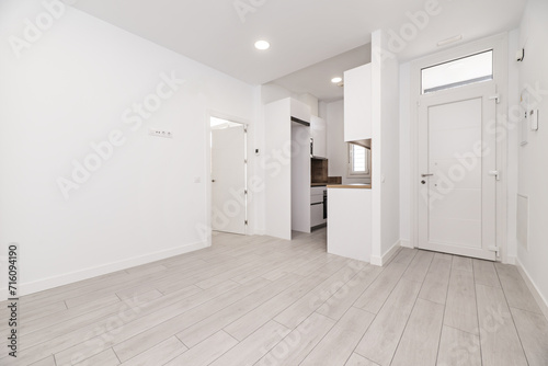 An empty white room in a loft-style house with an armored access door