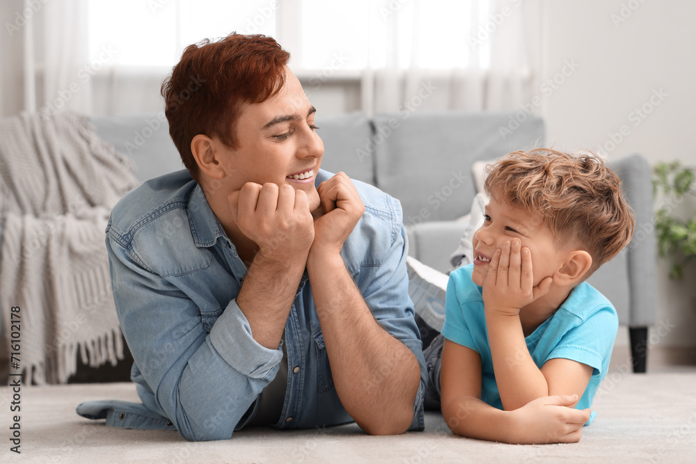 Little boy with his father lying on floor at home Little boy with his father lying on floor at home