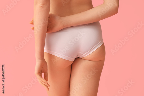 Beautiful young woman with cellulite problem on pink background, back view