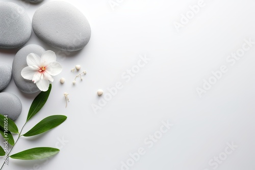 A visually pleasing arrangement of spa stones placed on a white background, accompanied by an empty space ideal for writing.