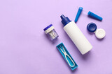 Containers for contact lenses with solution, tweezers and pipette on lilac background