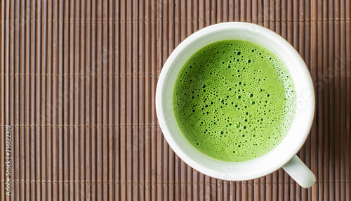 Green tea matcha in a white cup on the brown mat close-up. High quality photo