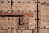 Close-up decorative iron door-hardware on old wooden paneled door