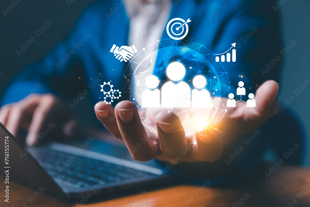 Employing CRM, the businessman manages global customer networks, leveraging technology for data exchanges and development, context of customer service, banking, and strategic business initiatives.