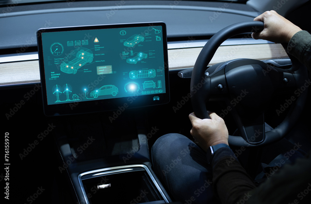 Person driving with futuristic electric vehicle dashboard display highlighting car features..