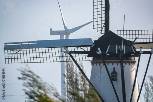 Traditional windmill and wind turbine juxtaposed in one image. photo