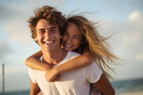 Happy couple enjoying piggyback riding at the beach in summer, relaxing