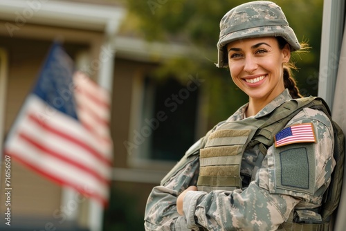 Happy American female soldier wearing military uniform with American flag In front of the house, happy service provides return home photo