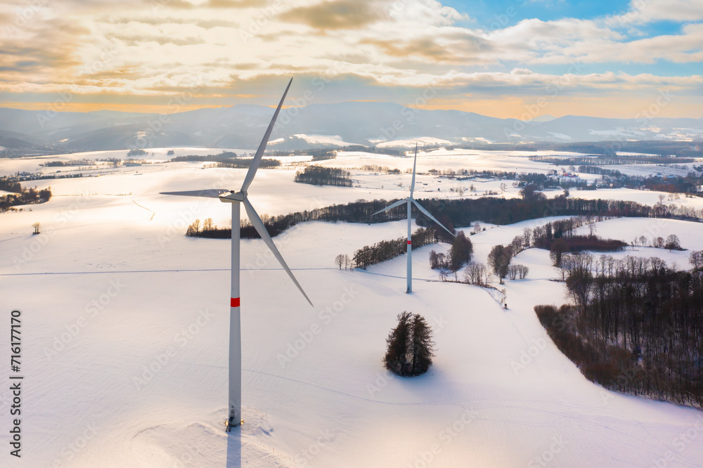Aerial view of wind turbines farm in winter at sunset. Renewable and clean energy. Aerial view of wind turbines farm in winter at sunset. Renewable and clean energy.