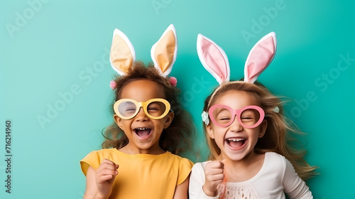 Two joyful girls in bunny ears celebrating easter photo