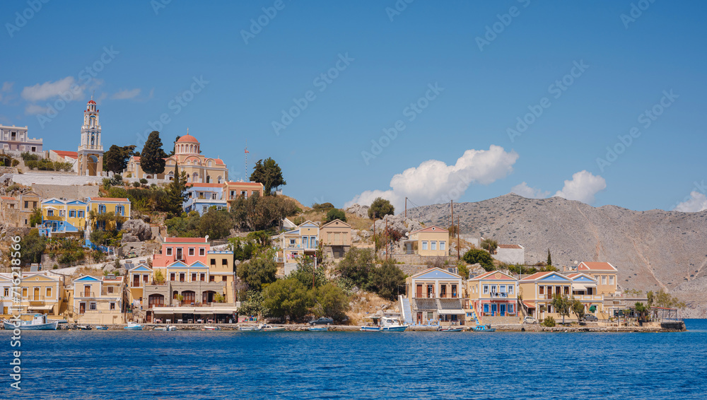 Symi Island, Greece. Greece islands holidays from Rhodos in Aegean Sea. Colorful neoclassical houses in bay of Symi. Holiday travel background. - obrazy, fototapety, plakaty 