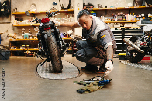 Mechanic choosing tool to use when fixing motorcycle