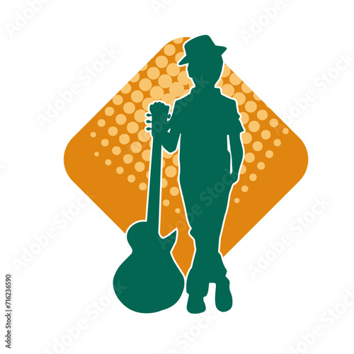 Silhouette of a young kid in pose with an acoustic guitar. Silhouette of a young musician in pose with acoustic guitar musical instrument.
