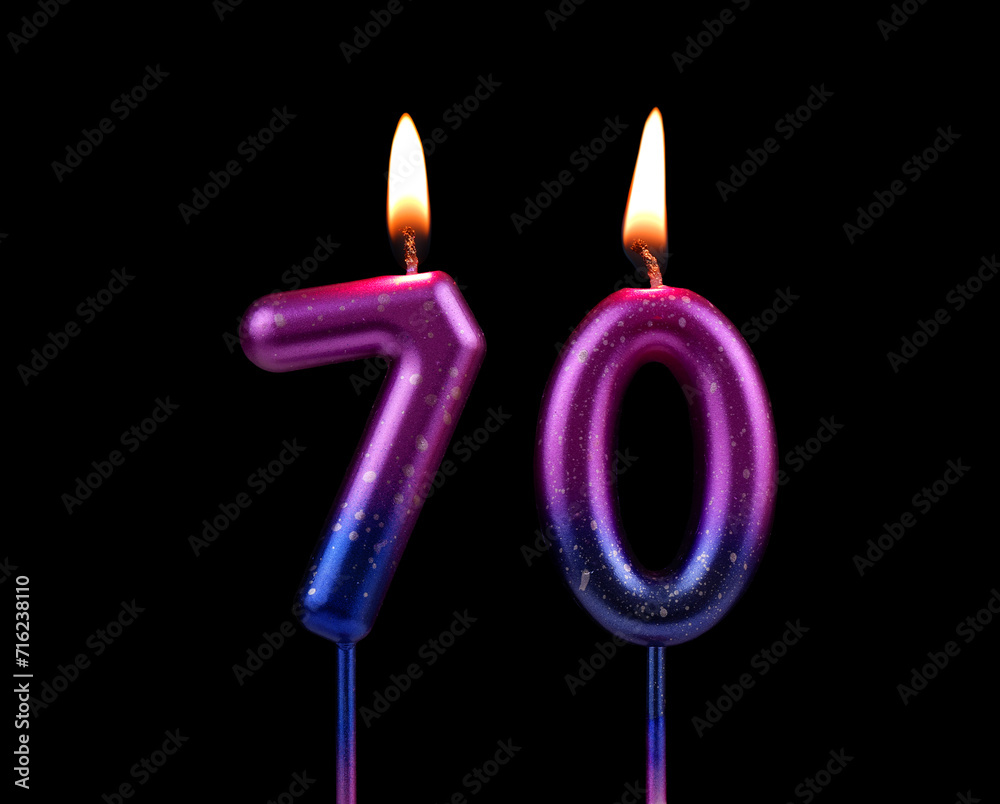Birthday cake candles burning on black background. Number 70.