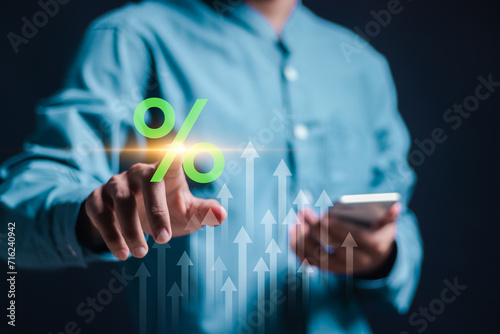 Businessman use touching virtual percentage icon and up arrow to analyzing company's business financial balance and calculates financial data for long-term investment.