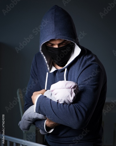 Criminal stealing baby in human child traficking concept