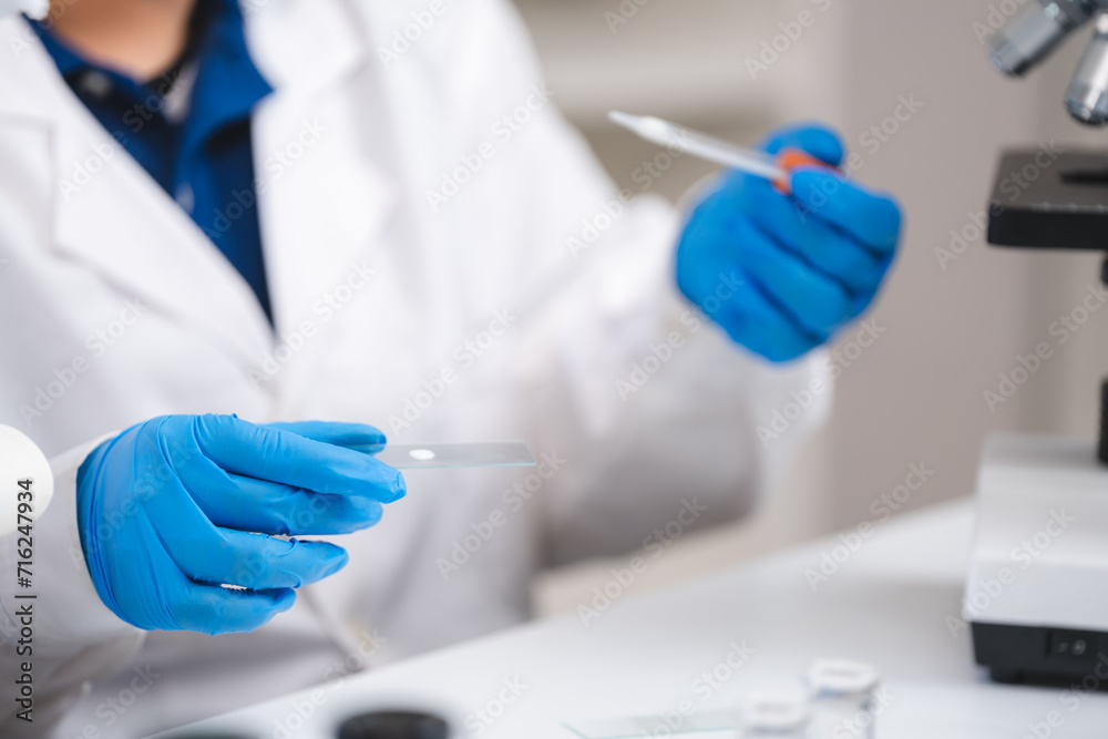Close up of scientist or nutritionist dripping a sample of milk, fat or glucose in a test tube or beaker in laboratory, Expertise is working on lactose, protein experiment analysis or testing quality. Close up of scientist or nutritionist dripping a sample of milk, fat or glucose in a test tube or beaker in laboratory, Expertise is working on lactose, protein experiment analysis or testing quality.