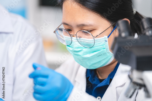 Scientists using microscope...