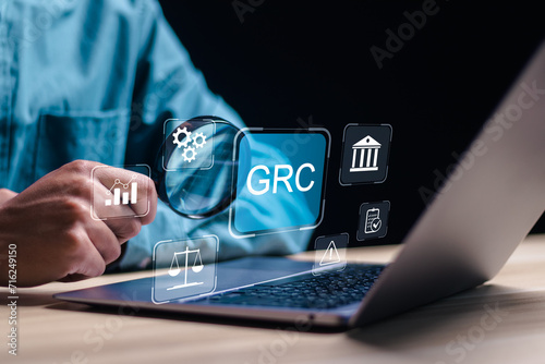 Boost efficiency with GRC Governance Risk and Compliance. Businessman use laptop with GRC icon on digital screen, structuring to align IT with business goals for optimal performance.