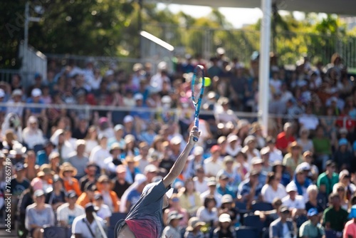 playing tennis on a blue tennis court. serving in a tennis with a crowd of fans watching in australian open photo