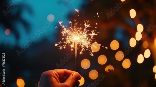 Hand Holding a Sparkler at a Vibrant Beach Party with Nighttime Firework Spectacle Ai Generated