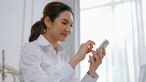 Young woman using smartphone browsing for online shopping E commerce by online payment gateway at vivancy home. Modern and convenience online purchasing make secure and convenient purchases.