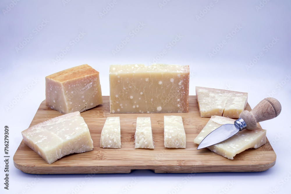 Italian Parmigiano Reggiano cheese on a wooden tray. Parmesan cheese.