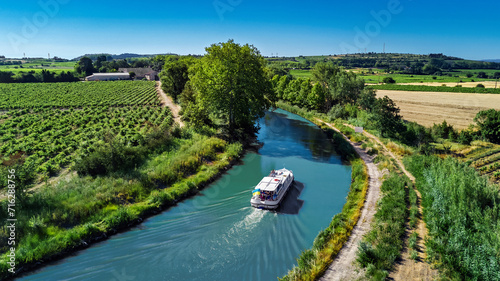 Aerial drone view of houseboat in Canal du Midi from above, family travel by boat, vacation in Southern France
 photo