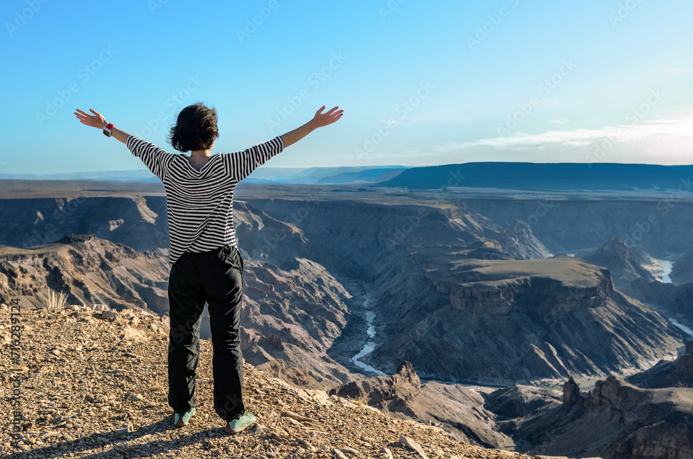 Woman looking at the Fish River Canyon in Namibia from the viewpoint, girl tourist travels Africa
Woman looking at the Fish River Canyon in Namibia from the viewpoint, girl tourist travels Africa