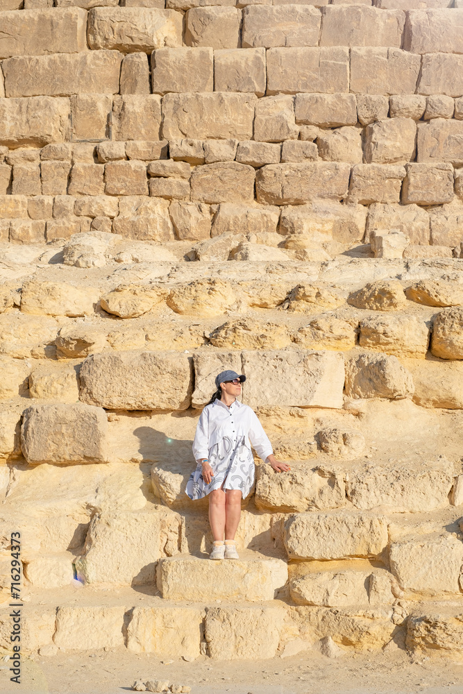 Woman wearing light clothing, facing the Pyramids of Gyza