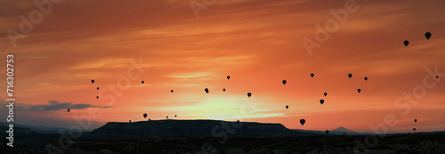Cappadocia landscape with silhouettes of hot air balloons in the morning sky, Nevsehir, Turkey