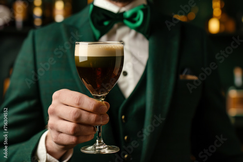 Irish coffee cocktail with an Irish bartender in green suit handing a glass of Irish coffee a cocktail made of whiskey, coffee and cream