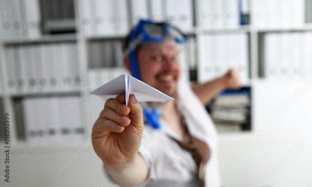 Man wearing suit and tie in goggles and snorkel play with fly paper plane in office closeup. Count days to leave annual day off workaholic freedom fun tourism resort idea ticket sale overseas concept Man wearing suit and tie in goggles and snorkel play with fly paper plane in office closeup. Count days to leave annual day off workaholic freedom fun tourism resort idea ticket sale overseas concept