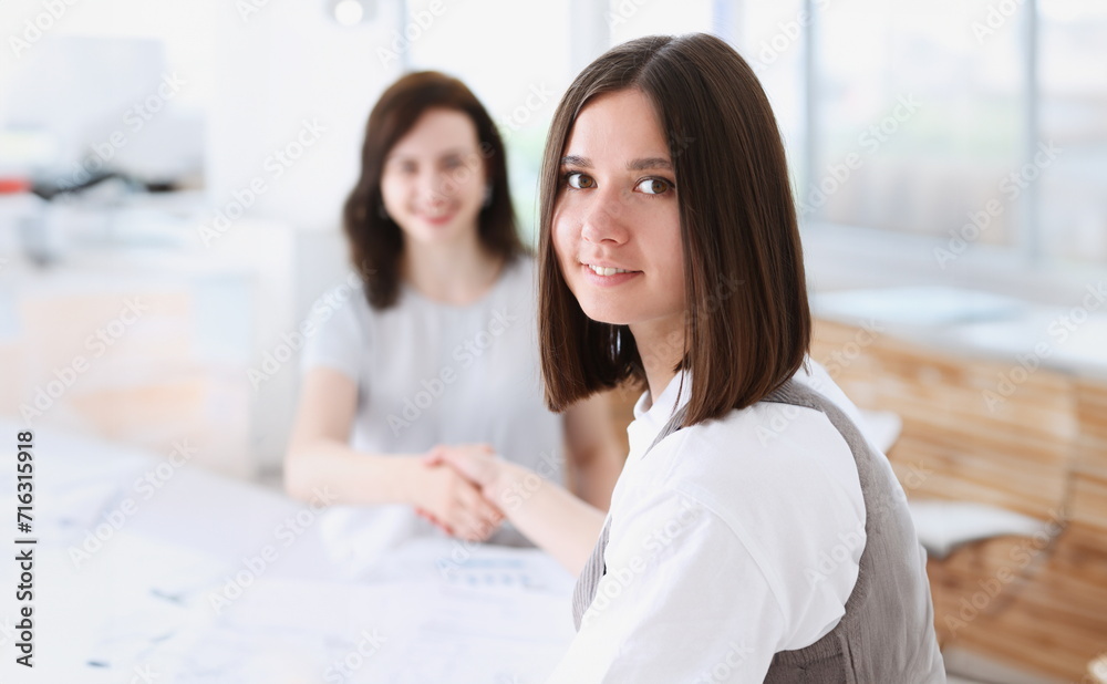 Businesswoman and woman shake hands as hello in office closeup. Friend welcome introduction greet or thanks gesture product advertisement partnership approval arm strike a bargain on portrait concept Businesswoman and woman shake hands as hello in office closeup. Friend welcome introduction greet or thanks gesture product advertisement partnership approval arm strike a bargain on portrait concept